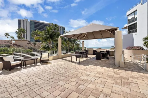a view of a patio with a table and chairs under an umbrella