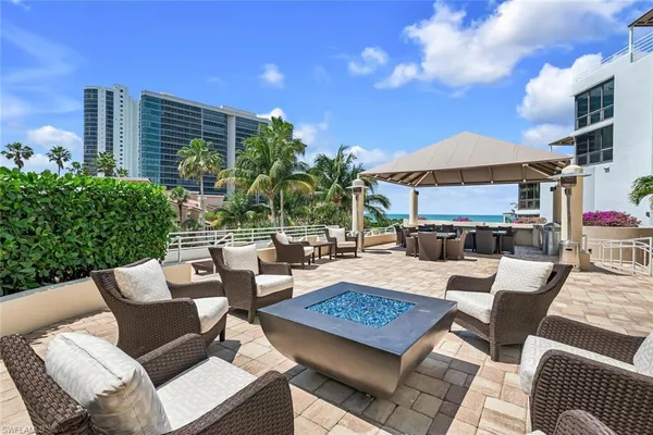 a view of a patio with couches and table and chairs with potted plants and big yard