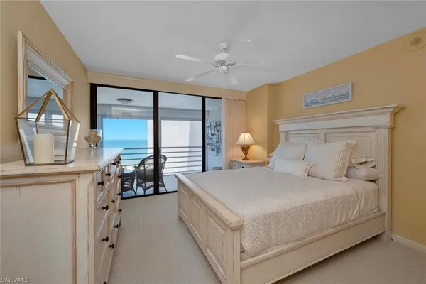 a bedroom with a bed a table and large mirror