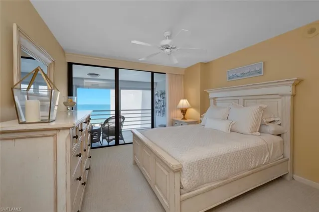 a bedroom with a bed a table and large mirror