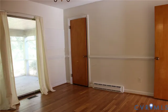 an empty room with wooden floor and a window