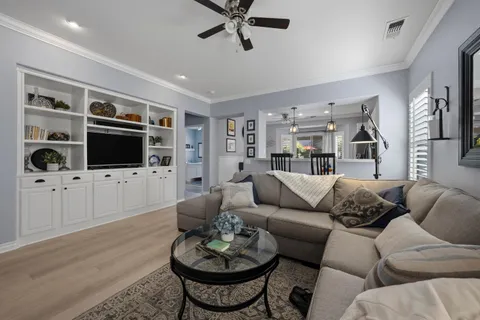 a living room with furniture a flat screen tv and kitchen view