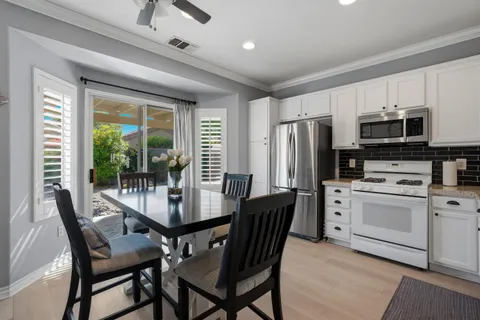 a dining room with furniture a chandelier and wooden floor