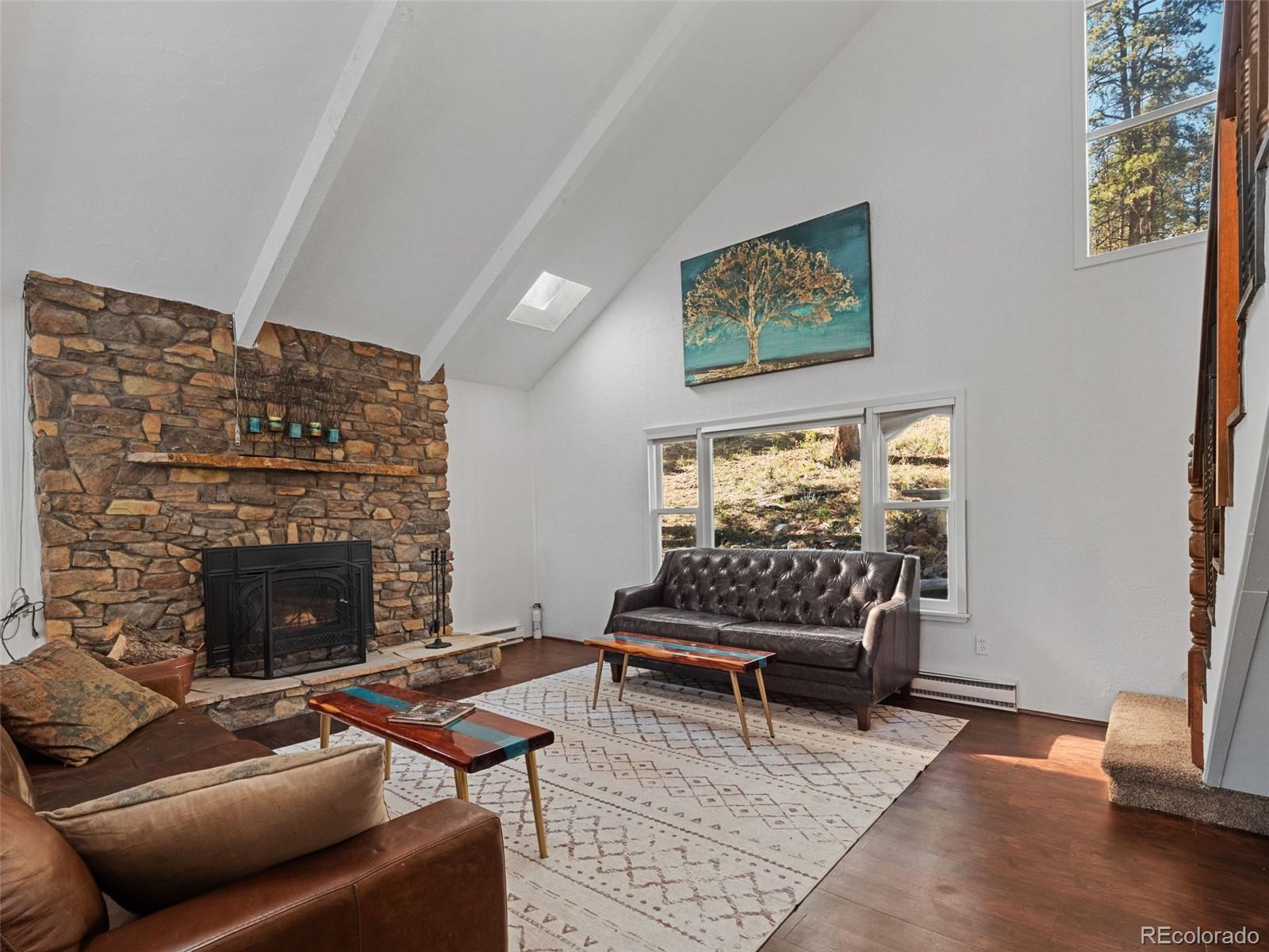 11825 South Little Turtle Lane Conifer, CO 80433 - Photo 14 of 34 a living room with furniture a rug and a fireplace