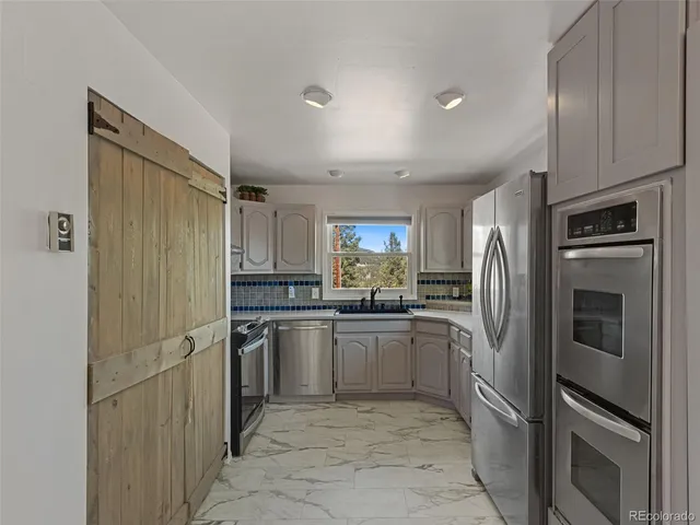a kitchen with stainless steel appliances granite countertop a sink stove and cabinets
