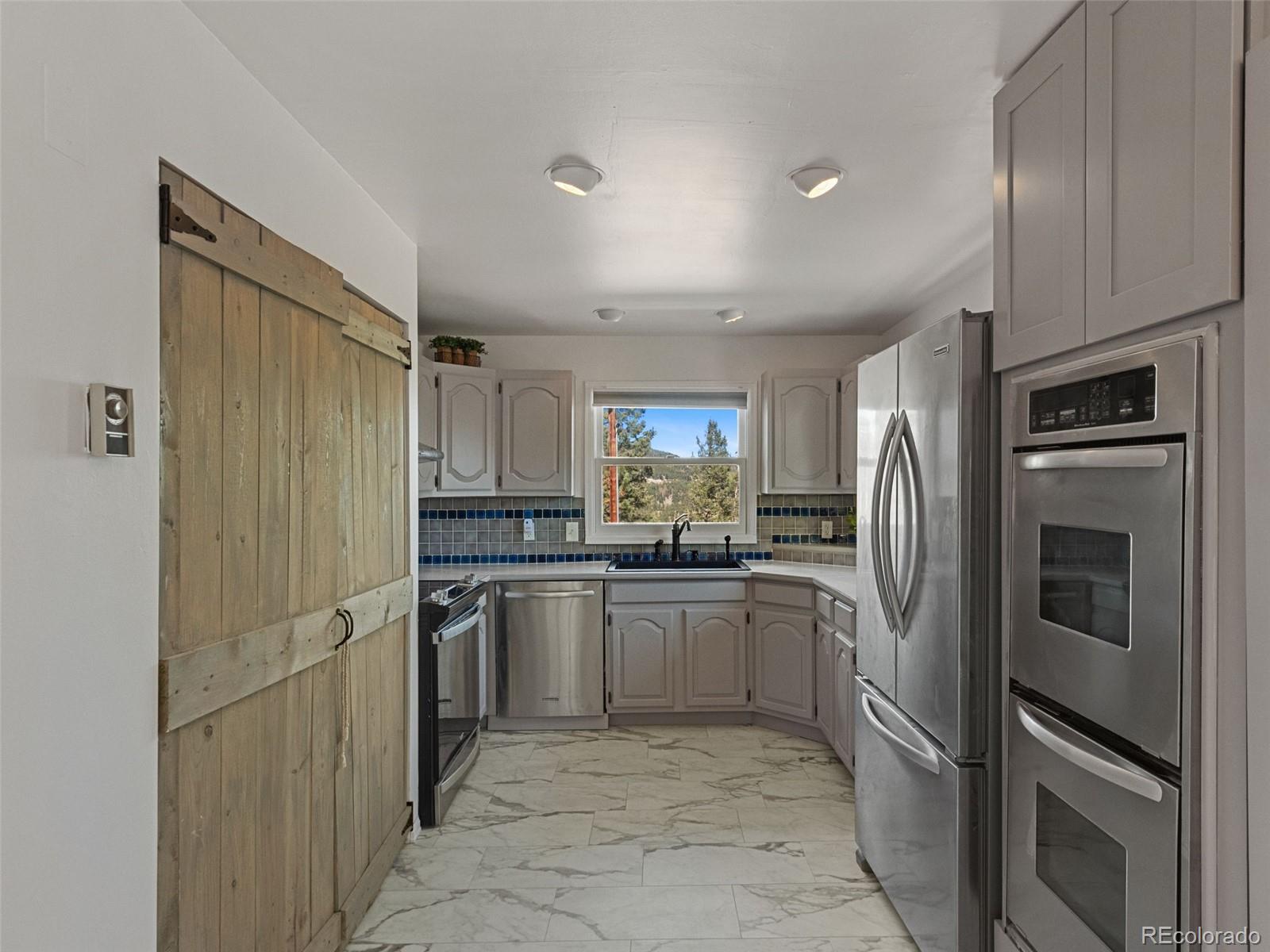 11825 South Little Turtle Lane Conifer, CO 80433 - Photo 19 of 34 a kitchen with stainless steel appliances granite countertop a refrigerator and a sink