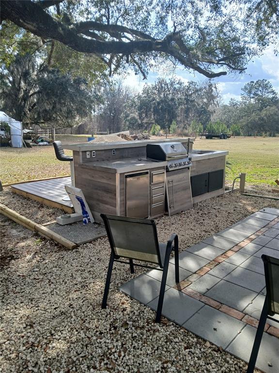 10360 County Road 18 Lake Butler, FL 32054 - Photo 31 of 43 a view of a backyard with table and chairs fire pit and large trees