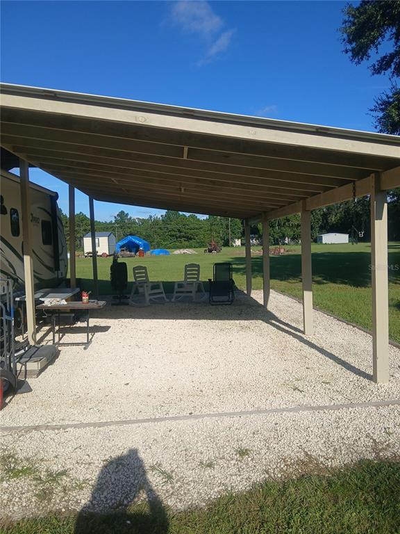 10360 County Road 18 Lake Butler, FL 32054 - Photo 38 of 43 a backyard with a table and chairs under an umbrella
