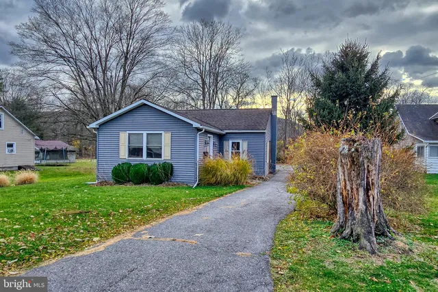 a front view of a house with a garden and yard