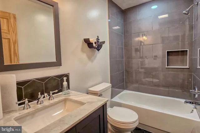 a bathroom with a sink toilet tub and shower