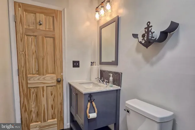 a bathroom with a toilet a sink and mirror