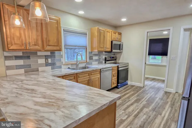 a kitchen with stainless steel appliances granite countertop a sink stove and wooden cabinets