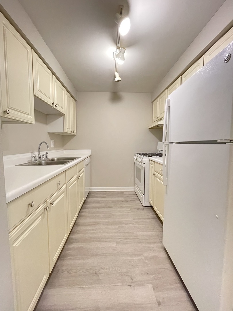 248 East Bailey Road, Unit K Naperville, IL 60565 - Photo 6 of 13 a kitchen with white cabinets and white appliances