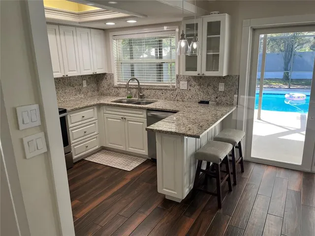 a kitchen with stainless steel appliances granite countertop a stove a sink and a refrigerator