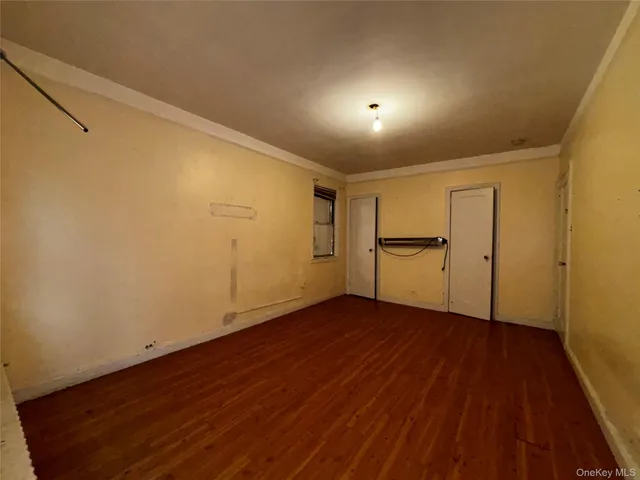 a view of empty room with wooden floor and cabinets