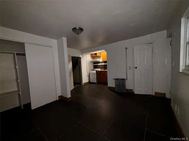 a view of a livingroom with wooden floor and a refrigerator