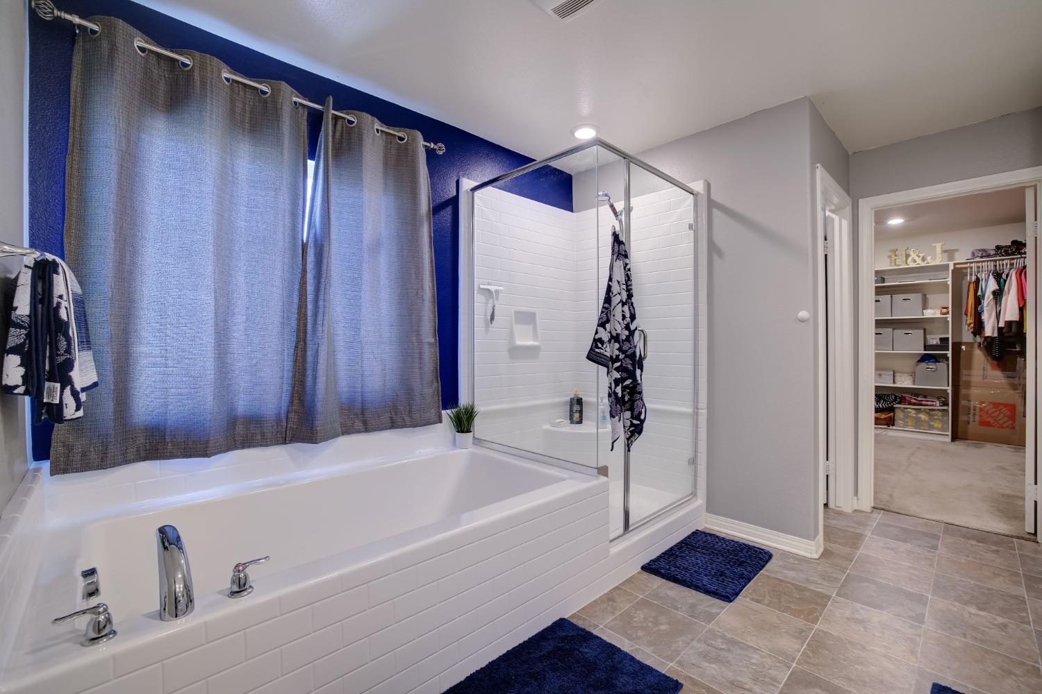 26055 Plumcot Drive Corona, CA 92883 - Photo 12 of 47 a bathroom with a bathtub and a shower