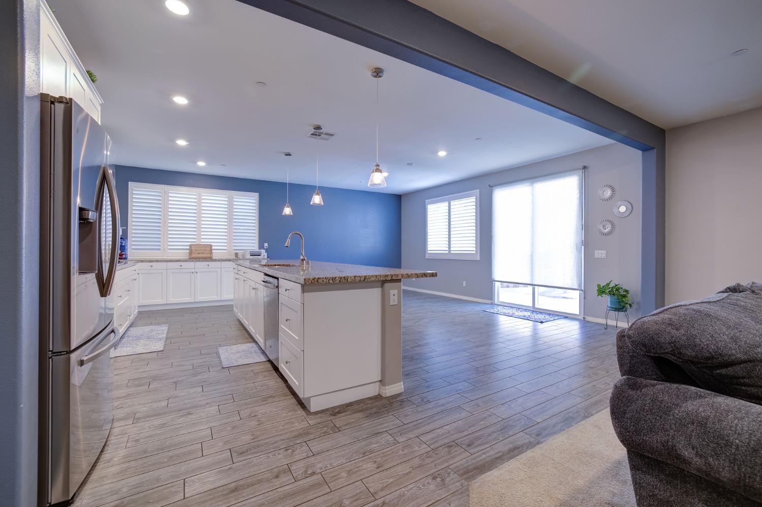 26055 Plumcot Drive Corona, CA 92883 - Photo 23 of 47 a living room with stainless steel appliances furniture large windows and wooden floor