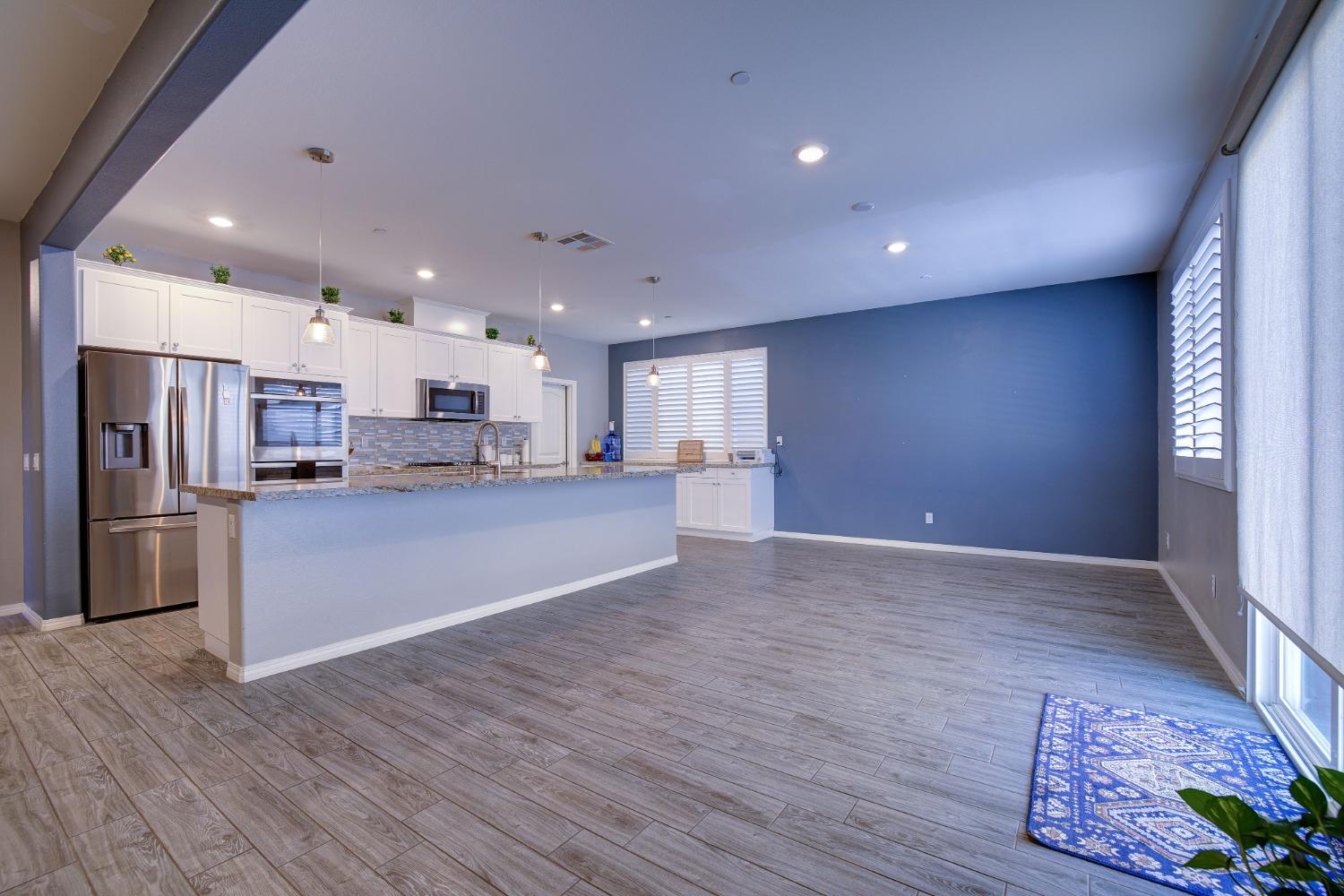 26055 Plumcot Drive Corona, CA 92883 - Photo 24 of 47 a view of kitchen with kitchen island wooden floor center island and stainless steel appliances