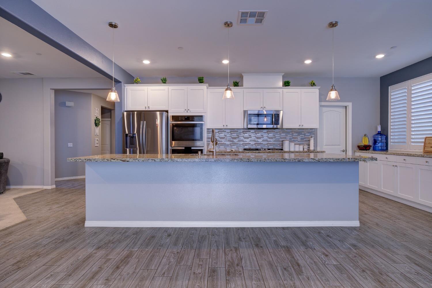 26055 Plumcot Drive Corona, CA 92883 - Photo 27 of 47 a living room with stainless steel appliances kitchen island granite countertop wooden floors and granite counter tops