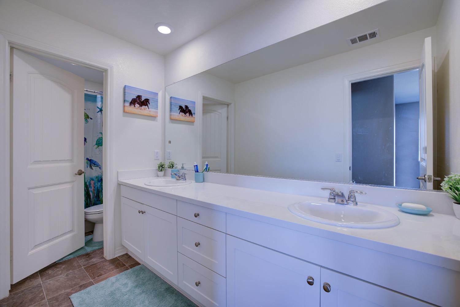 26055 Plumcot Drive Corona, CA 92883 - Photo 35 of 47 a bathroom with a sink and a mirror