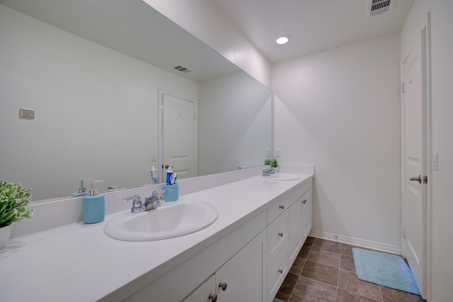 26055 Plumcot Drive Corona, CA 92883 - Photo 36 of 47 a bathroom with a double vanity sink and a mirror