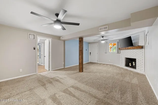 a view of empty room with fireplace and fan