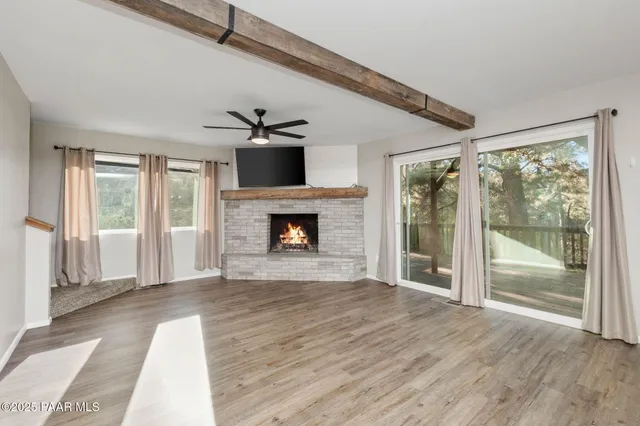 a view of empty room with wooden floor and fireplace