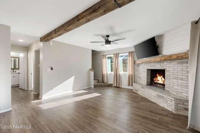 a view of a livingroom with wooden floor a fireplace and window