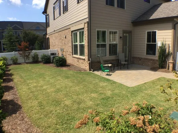 a view of an house with backyard and porch