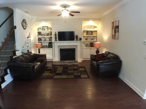 a living room with furniture a fireplace and a flat screen tv