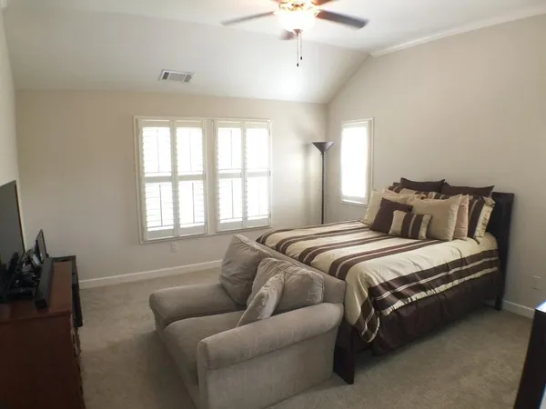 a bedroom with a bed couch and window