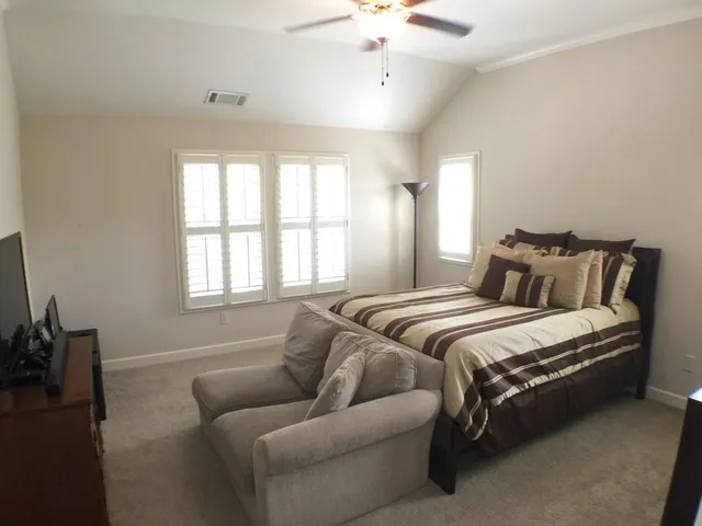 a bedroom with a bed couch and window