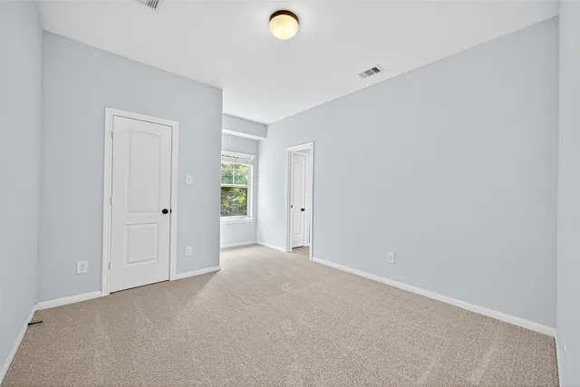 a view of a backyard with a large tree and wooden fence