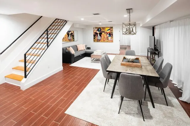 a view of a dining room with furniture a chandelier and wooden floor