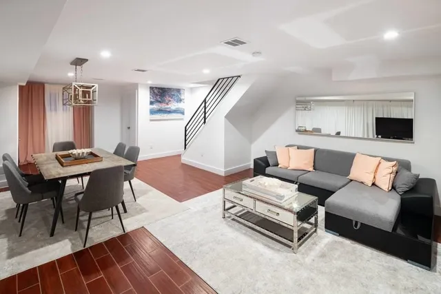 a living room with furniture and wooden floor