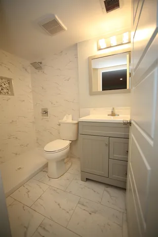 a spacious bathroom with a toilet sink and mirror