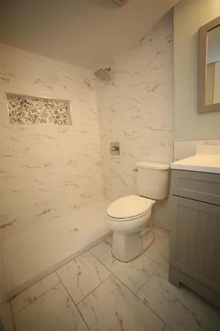 a bathroom with a toilet and a shower
