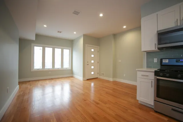 a kitchen with stainless steel appliances granite countertop a stove a sink and a microwave