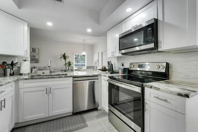 a kitchen with stainless steel appliances a stove microwave and sink