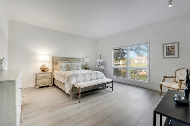 a bedroom with a bed and a large window