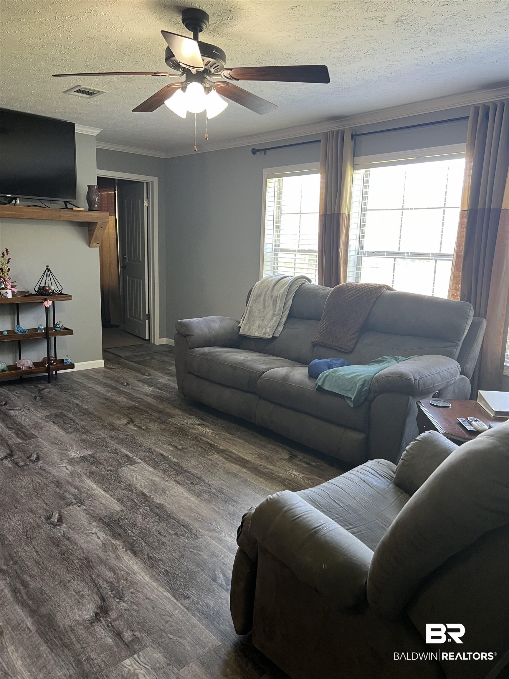 16824 Underwood Road Foley, AL 36535 - Photo 10 of 25 Living room with a textured ceiling, crown molding, dark hardwood / wood-style flooring, and ceiling fan