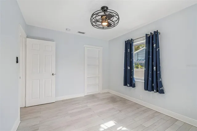 a front view of a house with a garden and trees