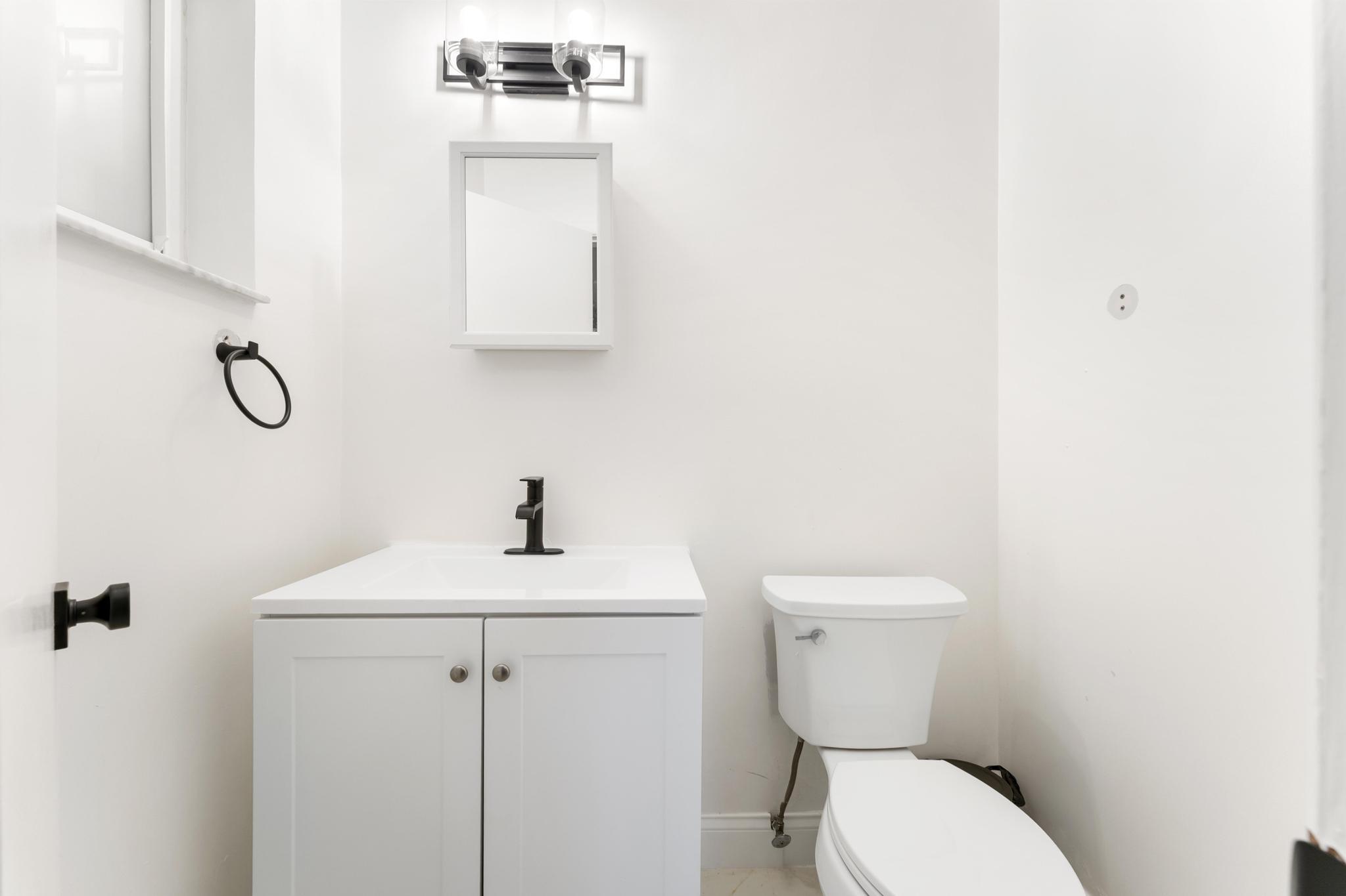 3179 Melaleuca Road West Palm Beach, FL 33406 - Photo 16 of 49 a bathroom with a toilet sink and mirror