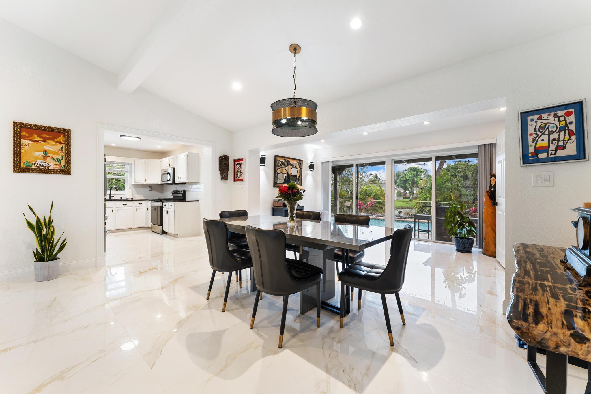 3179 Melaleuca Road West Palm Beach, FL 33406 - Photo 20 of 49 a view of a dining room and livingroom with furniture wooden floor a rug a painting and a chandelier