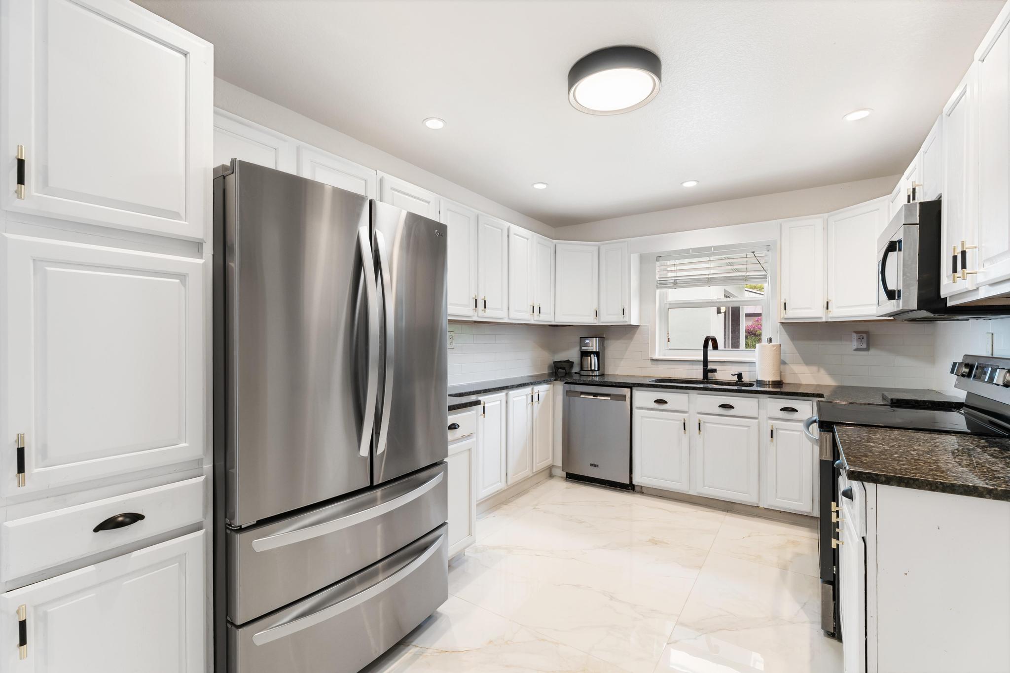 3179 Melaleuca Road West Palm Beach, FL 33406 - Photo 28 of 49 a kitchen with stainless steel appliances granite countertop a refrigerator sink and stove