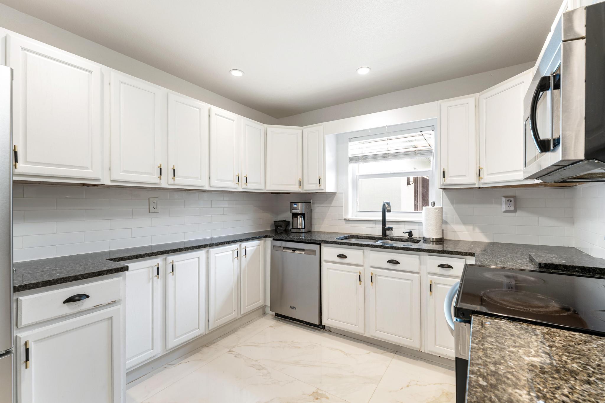 3179 Melaleuca Road West Palm Beach, FL 33406 - Photo 29 of 49 a kitchen with stainless steel appliances granite countertop a sink and cabinets