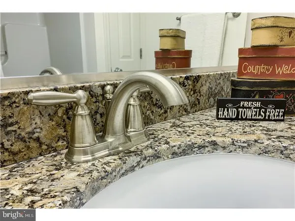 a bathroom with a granite countertop sink a toilet and a mirror