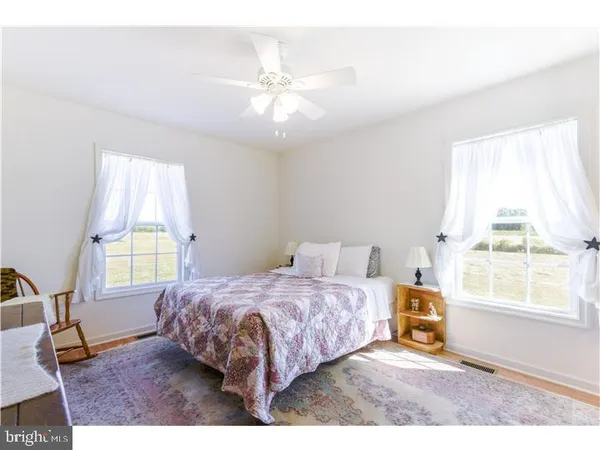 a bedroom with a bed and a ceiling fan