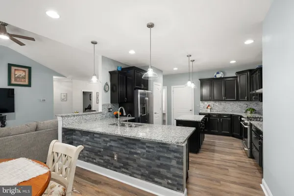 a kitchen with kitchen island granite countertop a stove and a sink